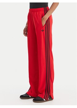 adidas Spodnie dresowe Firebird Classic KD3648 Czerwony Regular Fit ze sklepu MODIVO w kategorii Spodnie damskie - zdjęcie 188513294