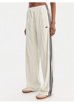 adidas Spodnie dresowe Terry Towel Firebird KQ6663 Écru Loose Fit ze sklepu MODIVO w kategorii Spodnie damskie - zdjęcie 188514221