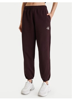 Calvin Klein Jeans Spodnie dresowe Monologo LV047B235G Brązowy Regular Fit ze sklepu MODIVO w kategorii Spodnie damskie - zdjęcie 188515660