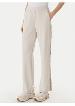 Guess Spodnie dresowe W6GB29 K3282 Beżowy Regular Fit ze sklepu MODIVO w kategorii Spodnie damskie - zdjęcie 189101770
