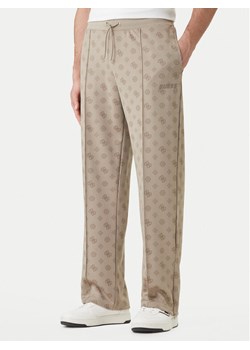 Guess Spodnie dresowe Z6GB03 K2850 Beżowy Regular Fit ze sklepu MODIVO w kategorii Spodnie męskie - zdjęcie 189101942