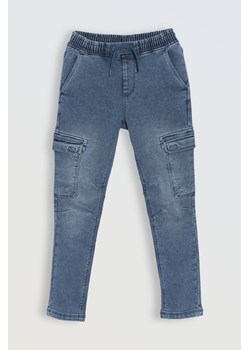 Niebieskie jeansowe spodnie typu cargo z przestrzennymi kieszeniami, Rozmiar - 140, Kolor - Niebieski ze sklepu REPORTER w kategorii Spodnie chłopięce - zdjęcie 189106412