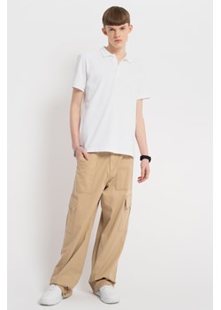 Beżowe spodnie materiałowe typu cargo z kieszeniami na nogawkach, Rozmiar - 170, Kolor - Beżowy ze sklepu REPORTER w kategorii Spodnie chłopięce - zdjęcie 189108331