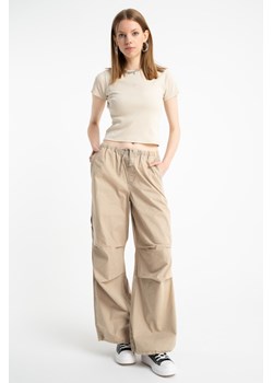 Beżowe spodnie typu PARACHUTE z zaszewkami na kolanach, Rozmiar - 152, Kolor - Beżowy ze sklepu REPORTER w kategorii Spodnie dziewczęce - zdjęcie 189109173