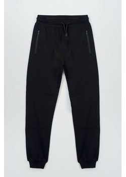 Czarne spodnie dresowe z modnymi cięciami na nogawkach, Rozmiar - 146, Kolor - Czarny ze sklepu REPORTER w kategorii Spodnie chłopięce - zdjęcie 189316504