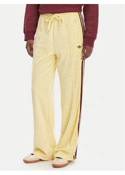 adidas Spodnie dresowe Terry Towel Firebird KQ6662 Żółty Loose Fit ze sklepu MODIVO w kategorii Spodnie damskie - zdjęcie 189346511